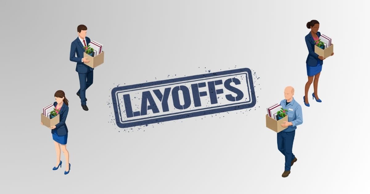 A professional in business attire sitting at a desk reviewing job search materials amid a wave of New Jersey layoffs in 2026