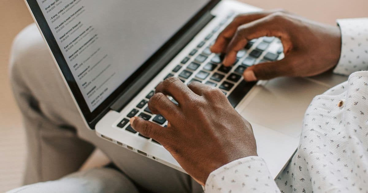 Professional candidate typing interview thank you email on laptop