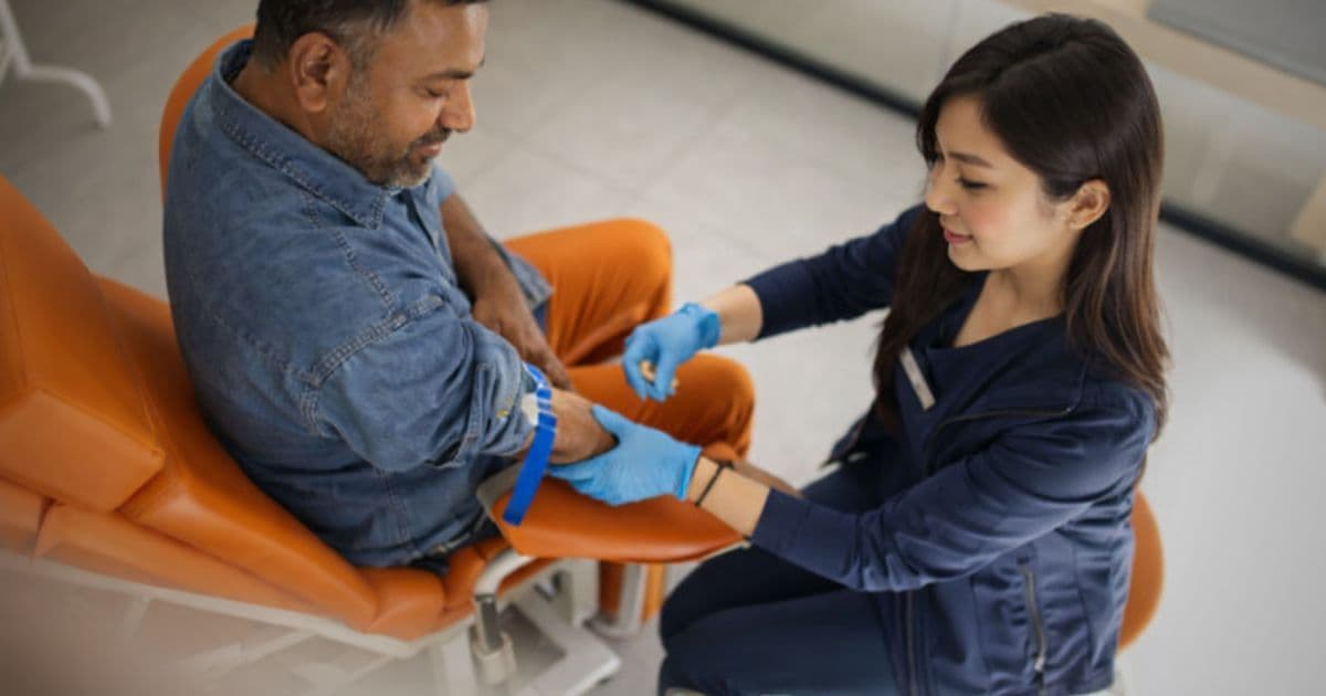 Phlebotomist writing a resume with medical tools and laptop, showcasing healthcare job application preparation