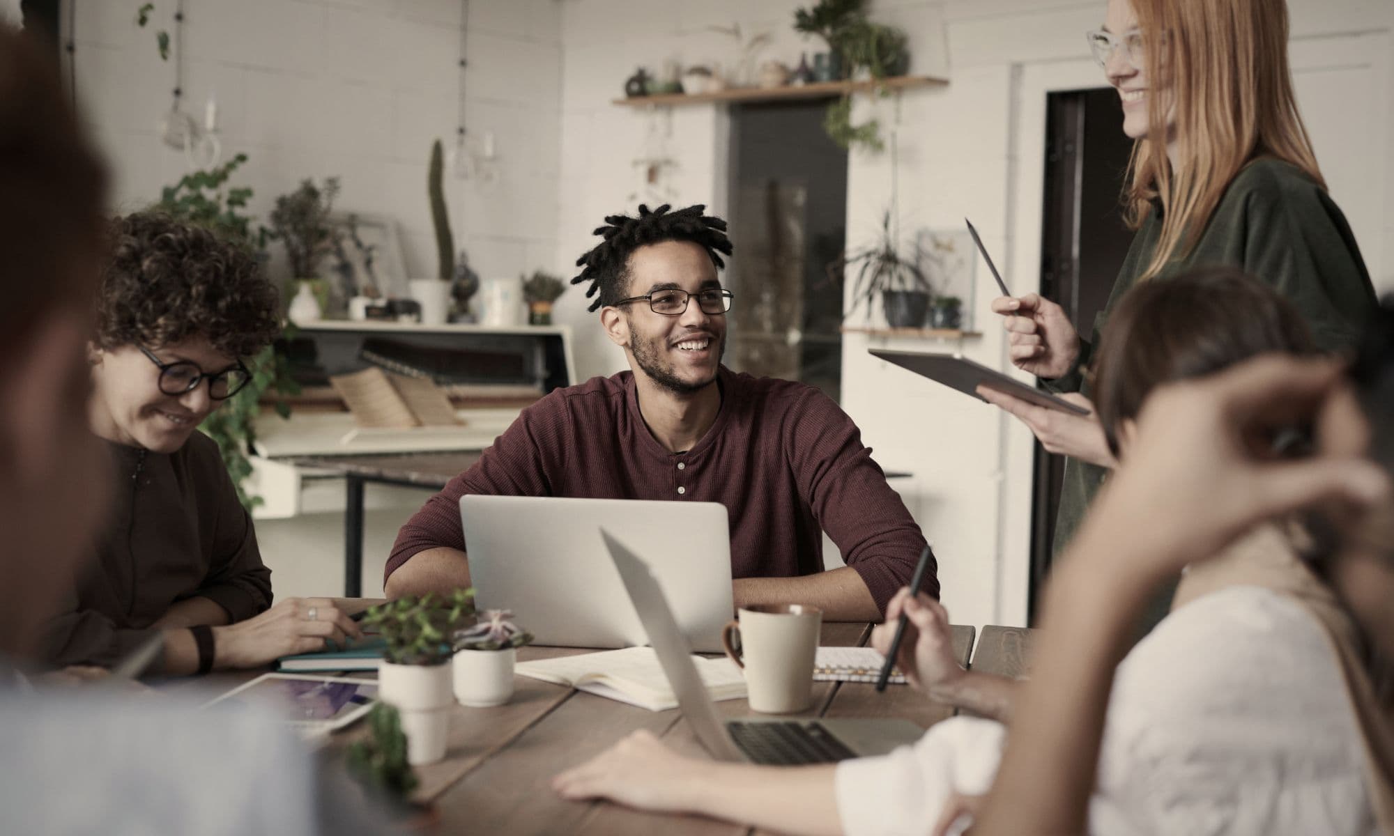 Young professionals discussing an internship opportunity in a collaborative office setting, representing decision-making around unpaid internship offers and career choices